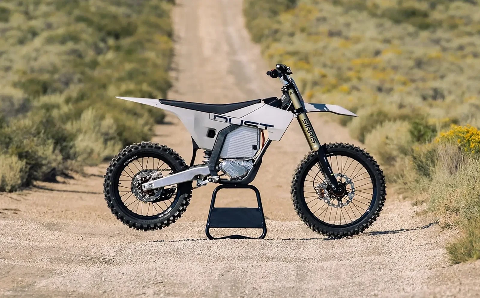 Una moto da cross elettrica Dust Moto su una pista polverosa